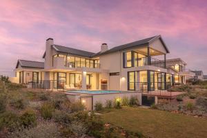 a house on the hill with a sunset at Water, views, vineyards, The Zen in Hermanus