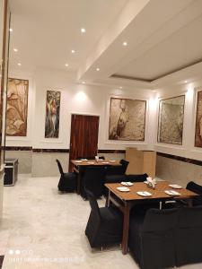 un ristorante con due tavoli, sedie e quadri di River Grand View Resort and SPA Manali - A River side Property a Manāli