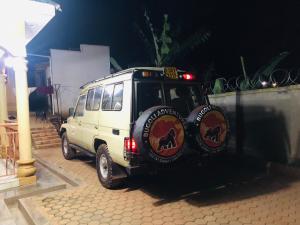 a white jeep parked in a parking lot at night at Gorilla Homestay Kabale in Kabale