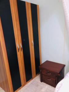 a bedroom with a wooden door and a table at Gorilla Homestay Kabale in Kabale