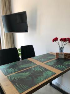 een tafel met twee stoelen en een televisie aan de muur bij Twoja Przystań SŁAWA- Apartament przy plaży in Sława