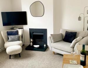 a living room with a couch and a fireplace at Bron Eryri - Our Cosy House opposite the entrance to Portmeirion! in Mynfford