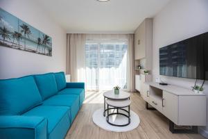 - un salon avec un canapé bleu et une table dans l'établissement GIL APARTMENTs 14, à Cracovie