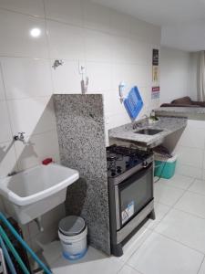 a kitchen with a stove and a sink at Apto Térreo - Condomínio Vila das Águas in Estância