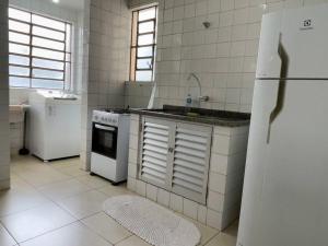 a kitchen with a white refrigerator and a sink at 5 coisas imperdíveis para fazer no Apto! MC32 in Maringá