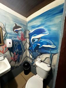 a bathroom with a dolphin painting on the wall at Hostel Rústico MarAbi in Tárcoles