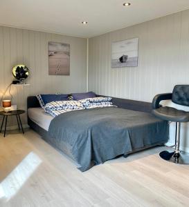 una camera con un grande letto e una sedia di Landlig beliggenhet med flott utsikt over Mjøsa 