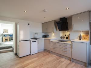 a kitchen with white cabinets and white appliances at The Laurels in Fraserburgh