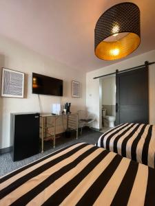 Rainbow Motel في غريلي: غرفة فندقية بسريرين وتلفزيون