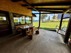 eine Veranda mit einer Holzbank vor einem Gebäude in der Unterkunft Holiday home Kraljica in Vlasic