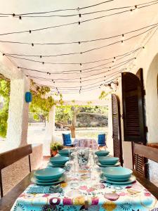 - une grande table avec des plats bleus sur la terrasse dans l'établissement Villa Stella, à Torre delle Stelle