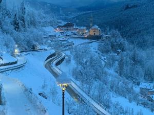 a snow covered village with a street light in the foreground at La Ciasa Dell'Emigrante in Cibiana +21 photos
