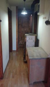 a room with a kitchen with a wooden floor at La Ciasa Dell'Emigrante in Cibiana