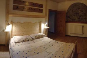 a bedroom with a large bed with white sheets and pillows at La Ciasa Dell'Emigrante in Cibiana