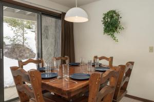 a dining room table with chairs and a large window at Hideaway Village Alpine 4 in Winter Park