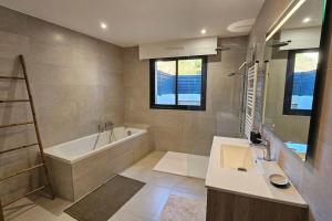 a bathroom with a tub and a sink and a bath tub at Nouveau Superbe appartement - Rsd Calypso Tiuccia in Casaglione +21 photos