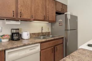 a kitchen with a sink and a refrigerator at Hideaway Village Alpine 4 in Winter Park