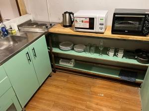une cuisine avec un comptoir et un four micro-ondes sur une étagère dans l'établissement Bello depto en la nieve Juncal, à Los Penitentes