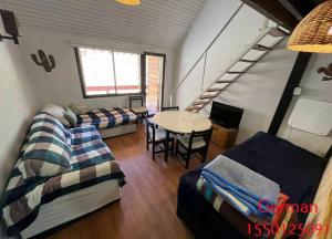 Pokój z 2 łóżkami, stołem i schodami w obiekcie Bello depto en la nieve Juncal w mieście Los Penitentes