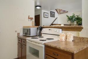 a kitchen with a white stove and a microwave at Hideaway Village Alpine 4 in Winter Park