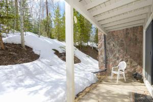 a white chair sitting on a porch in the snow at Hideaway Village Alpine 4 in Winter Park