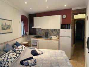 a small kitchen with a bed and a refrigerator at LA CASETTA DI REBY in Albano Laziale