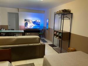 Sala de estar con 2 camas y TV en Loft no Recreio, en Río de Janeiro