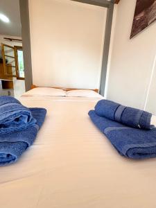 Dos camas en una habitación con toallas azules. en Guesthouse Rondo, en Himare