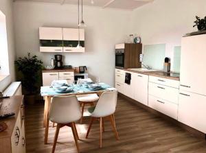 een keuken met een tafel en stoelen in een kamer bij Traumhaftes Studioappartement in Wadern