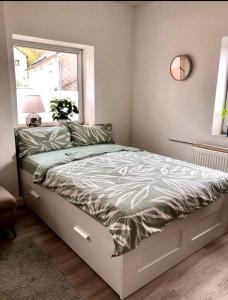 een slaapkamer met een groot bed met een klok aan de muur bij Traumhaftes Studioappartement in Wadern