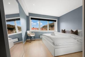a bedroom with a white bed and two windows at Scandinavian Style Apartement! Balcony and Stunning Views! in Bergen