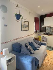 un sofá azul en una habitación con cocina en LA CASETTA DI REBY, en Albano Laziale