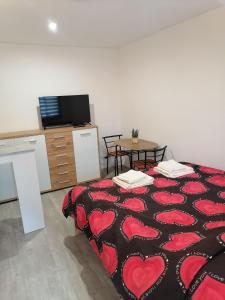 a room with a bed with red hearts on it at Studio Třeboň in Třeboň +2 photos