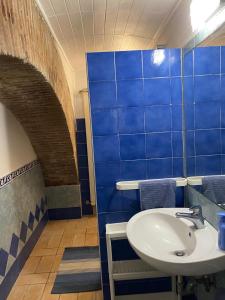 baño con lavabo y paredes de azulejos azules en LA CASETTA DI REBY, en Albano Laziale