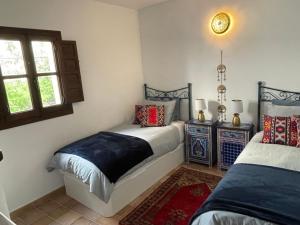 a bedroom with two beds and a window at Casa Morayma, Lecrin, Granada in Acequias