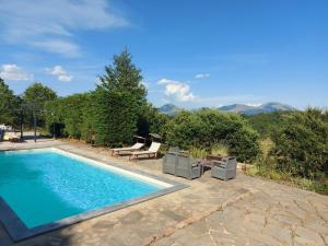 una piscina con 2 sillas y un tobogán en BnB Bagno di Bosco, en Gubbio