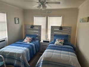 a bedroom with two beds and a ceiling fan at Key Largo Surfside Beach, Texas in Freeport