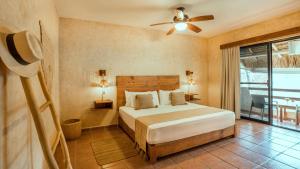a bedroom with a bed and a ceiling fan at Hotel Colibri Beach in Playa del Carmen