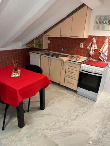 a kitchen with a table with a red table cloth on it at Apartman Sun house Kumbor 2 in Herceg-Novi