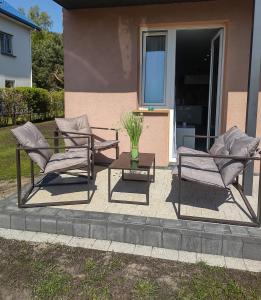 two chairs and a table in front of a house at Apartament U Bosmana in Dźwirzyno