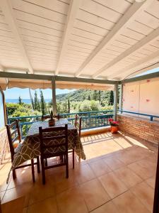 patio con mesa y sillas en el balcón en Guesthouse Rondo, en Himare
