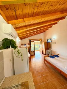 una sala de estar con cama y una habitación con techo en Guesthouse Rondo, en Himare