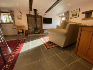 a living room with a couch and a fireplace at Oaklands Cottage on a rural farm in Dingestow