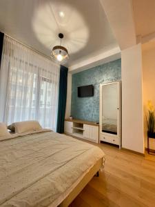 - une chambre avec un grand lit et un grand miroir dans l'établissement Seaside Apartments Mamaia Nord, à Mamaia Nord – Năvodari