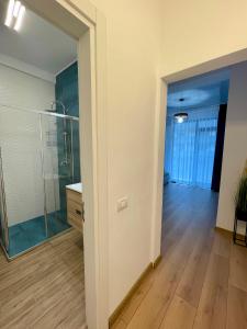 La salle de bains est pourvue d'une douche en verre et d'un lavabo. dans l'établissement Seaside Apartments Mamaia Nord, à Mamaia Nord – Năvodari