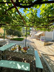 una mesa de picnic con comida bajo un dosel en Guesthouse Rondo, en Himare