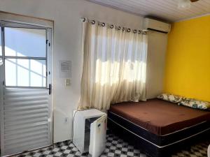 a small room with a bed and a window at Suites do Rafa Ubatuba in Ubatuba