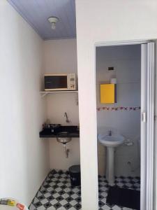 a small bathroom with a sink and a microwave at Suites do Rafa Ubatuba in Ubatuba