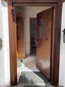 a wooden door leading into a room with a hallway at Ferienwohnung im Grünen in Zaberfeld