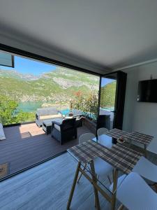 a living room with a deck with a table and chairs at Koman Paradise by Romina in Shkodër